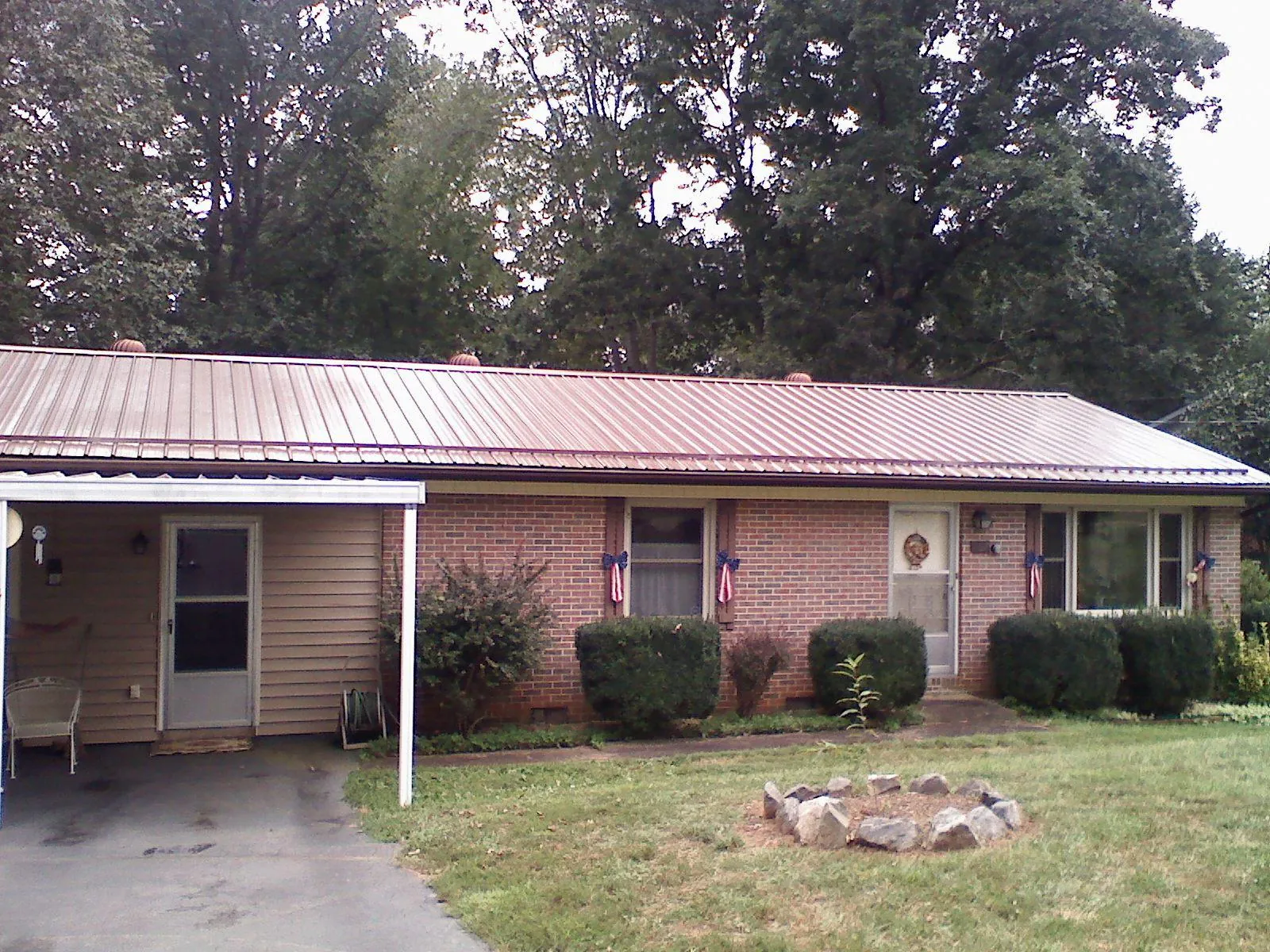 Bronze metal roof and carport on a brick ranch home — Roof Repair work by our crew in Fennville